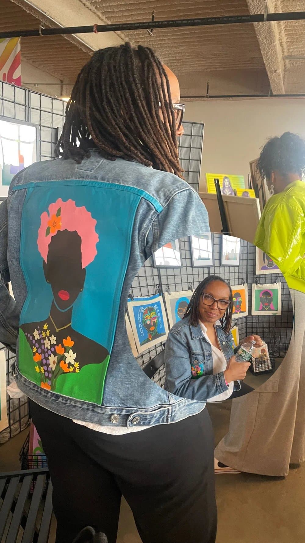 A denim jacket with a painted portrait on the back
